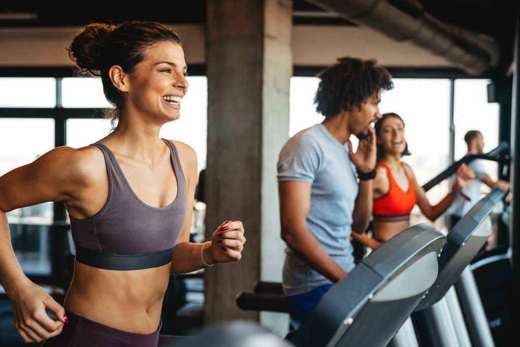 Sport gym exercise and people concept. Happy fit people working out in gym